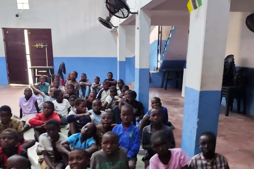 Children seated at the chapel of the mission