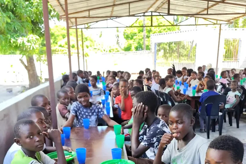Children at the table during a meal served by the mission