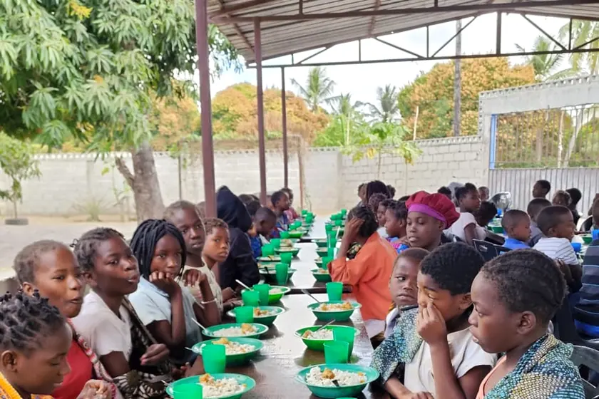 Children and volunteers sharing a meal together